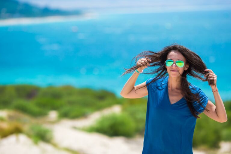 ragazza al mare che indica capelli rovinati dal mare