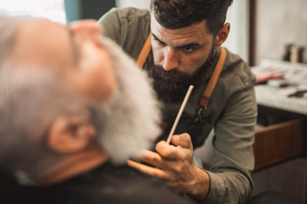 Barbiere professionale durante modellatura barba uomo